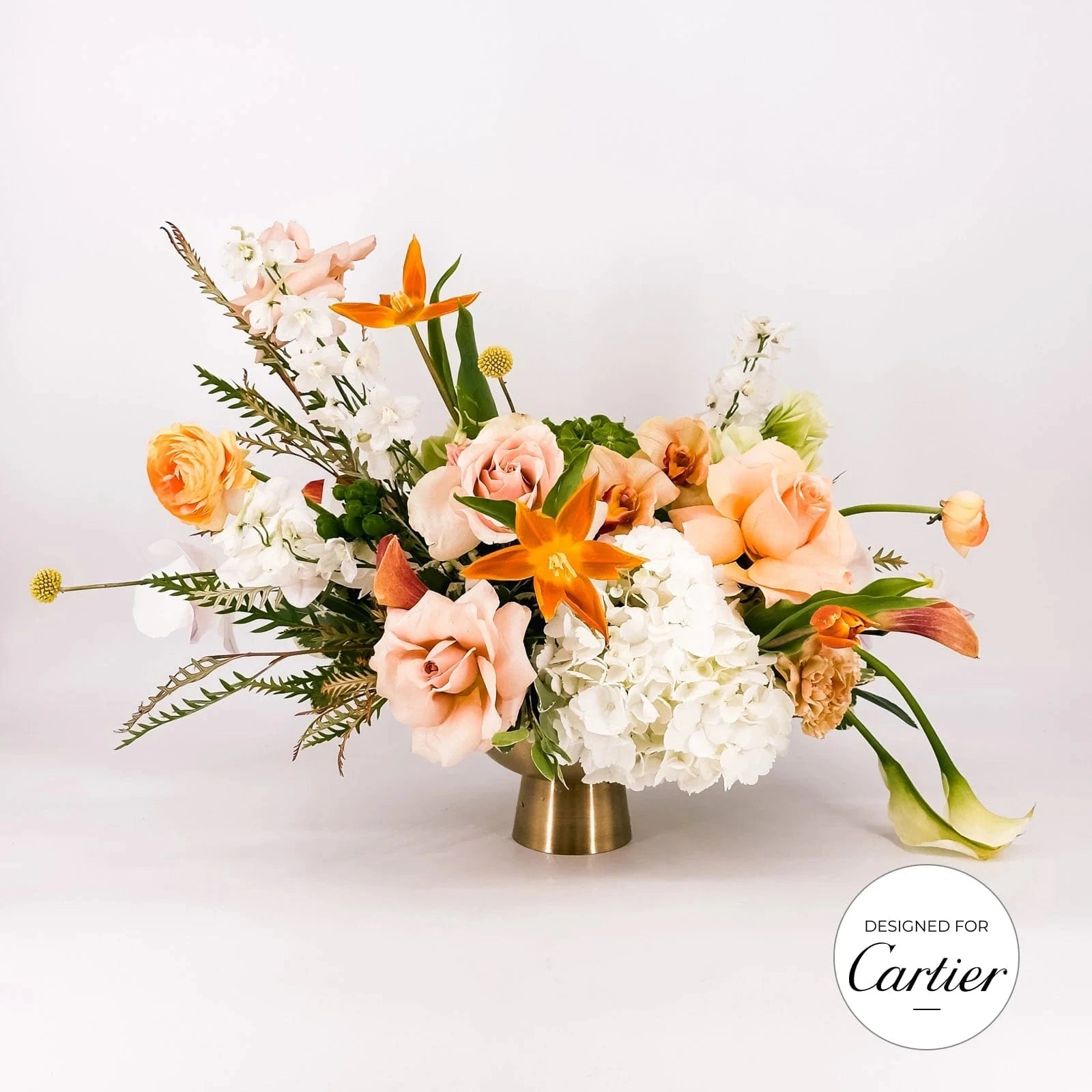 Luxury Golden Elegance flower arrangement with peach roses, white hydrangeas, and orange lilies, designed for Cartier by Flowers Valley.