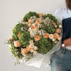 Verdant Elegance bouquet with apricot roses and green hydrangeas wrapped in white paper