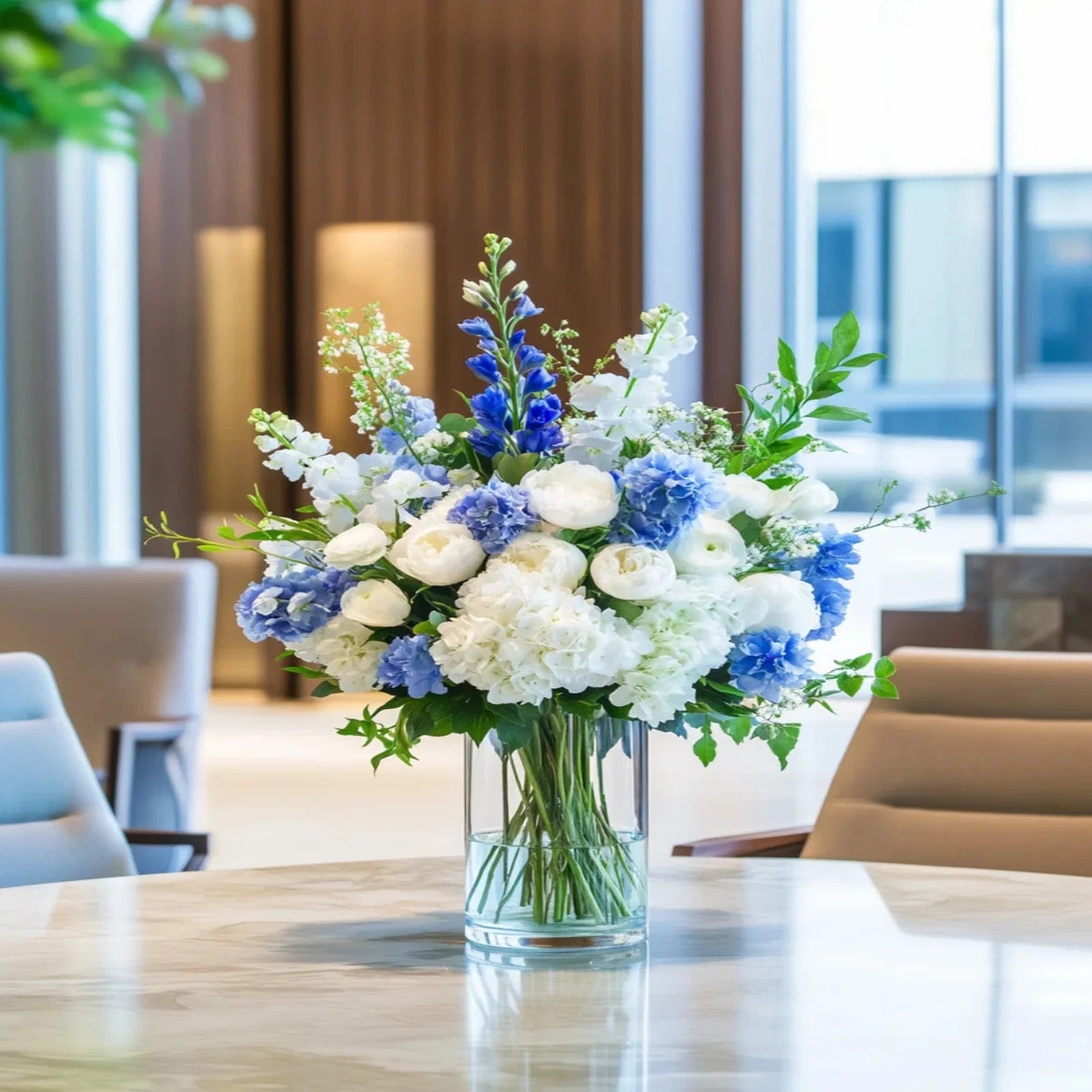Elegant conference room flower arrangement with blue hydrangeas, white roses, and lush greenery – Flowers Valley