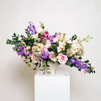 Enchanted Garden bouquet with pink and purple blooms in a sculptural vase arrangement
