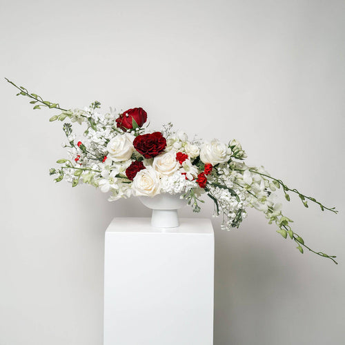 Burgundy Symphony bouquet with red and ivory roses in a ceramic vase