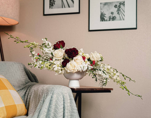 Modern rose arrangement in red and cream on a nightstand