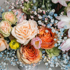 Detail of soft pink ranunculus and peach roses in Morning Bloom bouquet