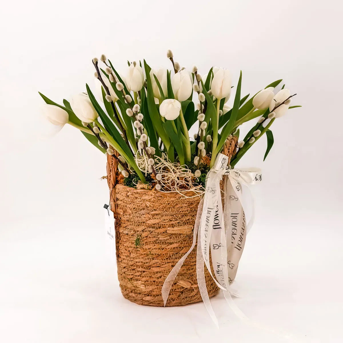 White tulips in a woven Easter basket arrangement