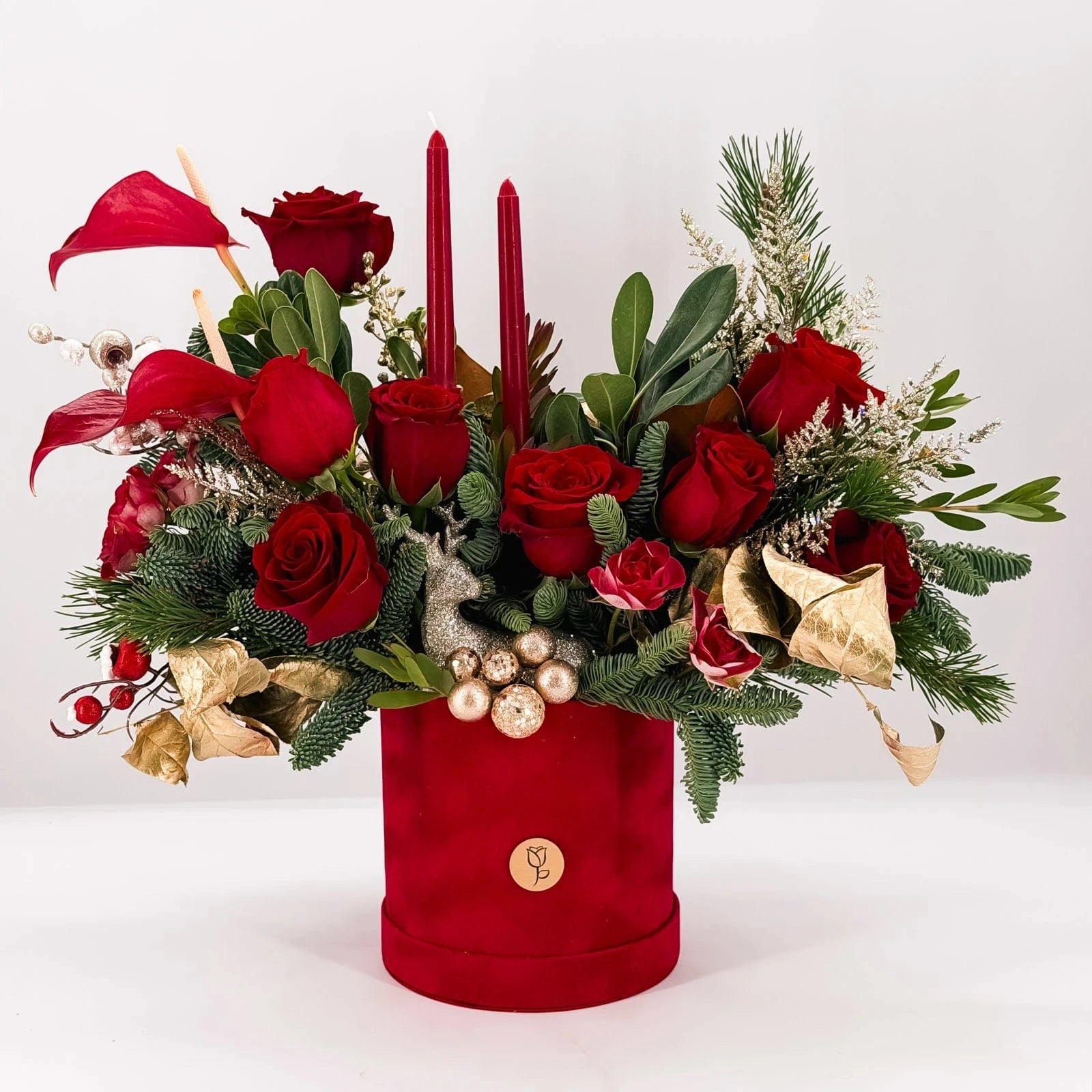 Scarlet Lights Arrangement with red roses, candles, anthuriums, and Christmas greenery in velvet hatbox