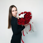 Woman holding Orchid Embrace rose and orchid bouquet wrapped for gifting
