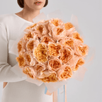 Hand-tied bouquet of peach garden roses wrapped in soft cream paper