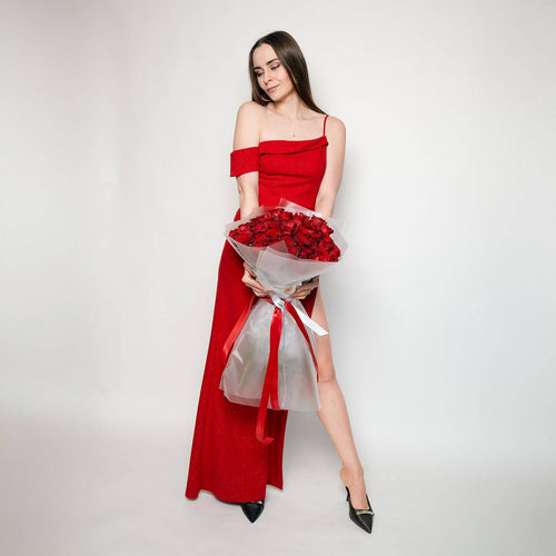 Model in red holding a large bouquet of Grand Prix roses.