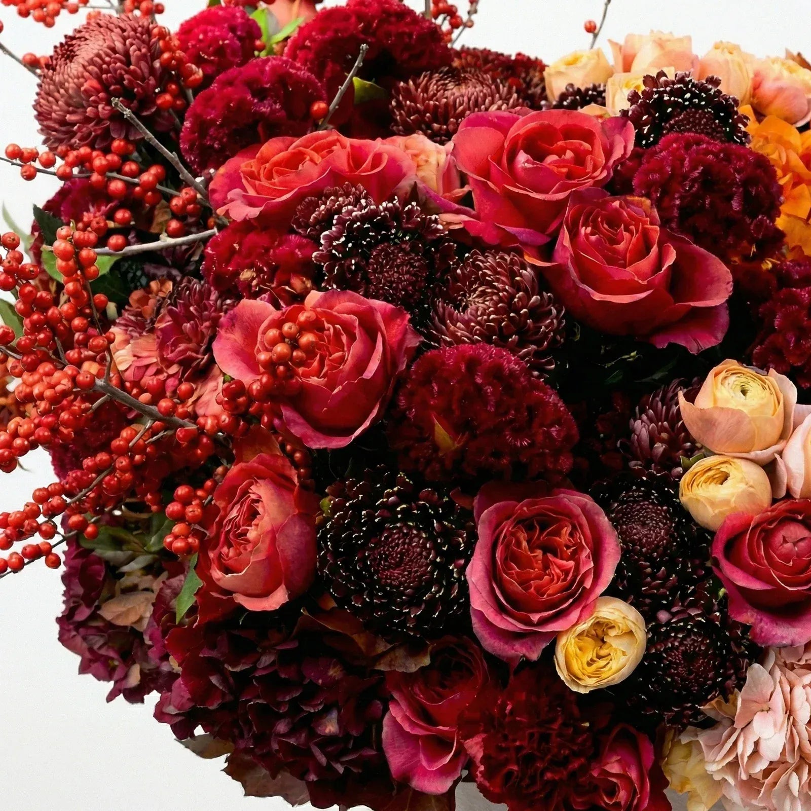 Close-up of claret red and burgundy flowers with autumn textures in Amber & Claret arrangement