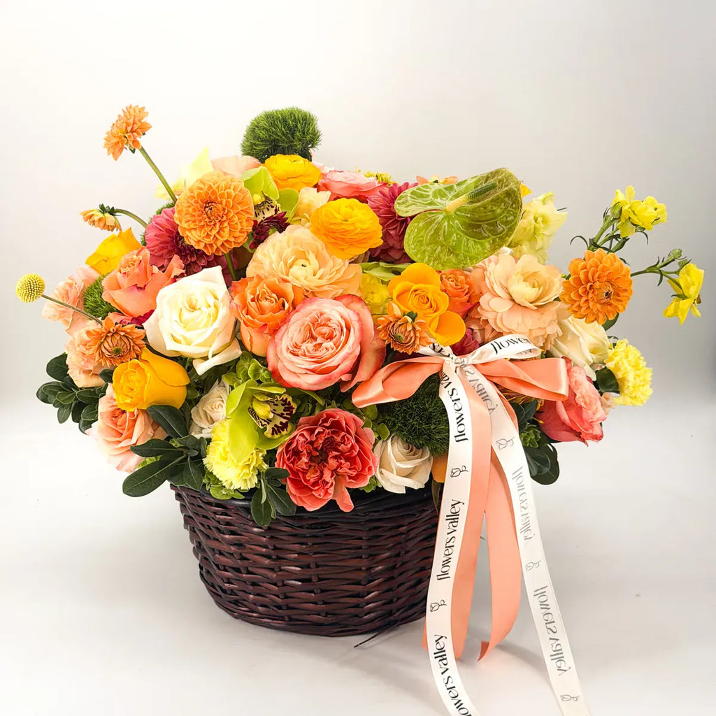 Apricot Orchard fall flower basket with peach garden roses, orange dahlias, ranunculus, and green cymbidium orchids, tied with the Flowers Valley ribbon — same-day Bay Area delivery