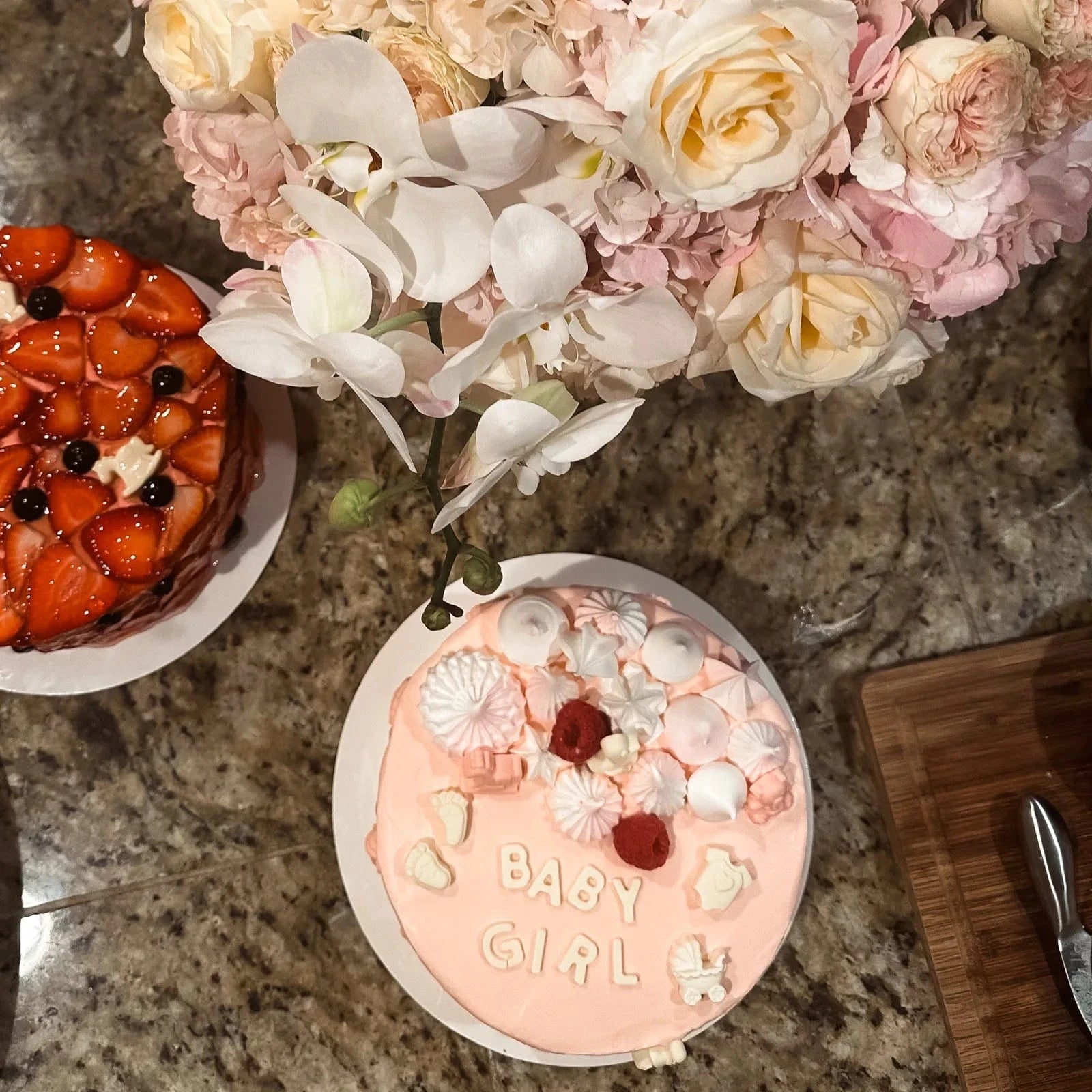 Baby Girl Bloom Box with soft pink flowers, cake, and orchids on a table