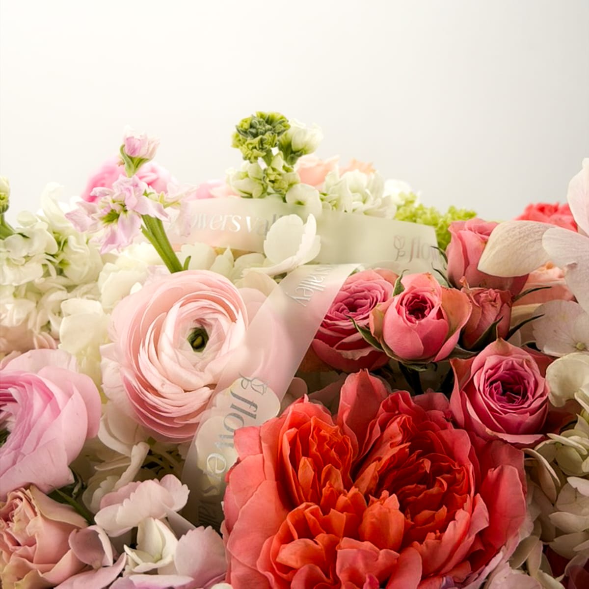 Close-up of blush roses, ranunculus, and soft pink hydrangea in a luxury floral design