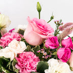 Blushing Grace floral arrangement with blush roses, pink carnations, and white lisianthus in a silver mirrored vase with ribbon.