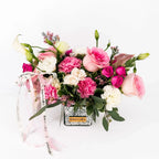 Blushing Grace floral arrangement with blush roses, pink carnations, and white lisianthus in a silver mirrored vase with ribbon.