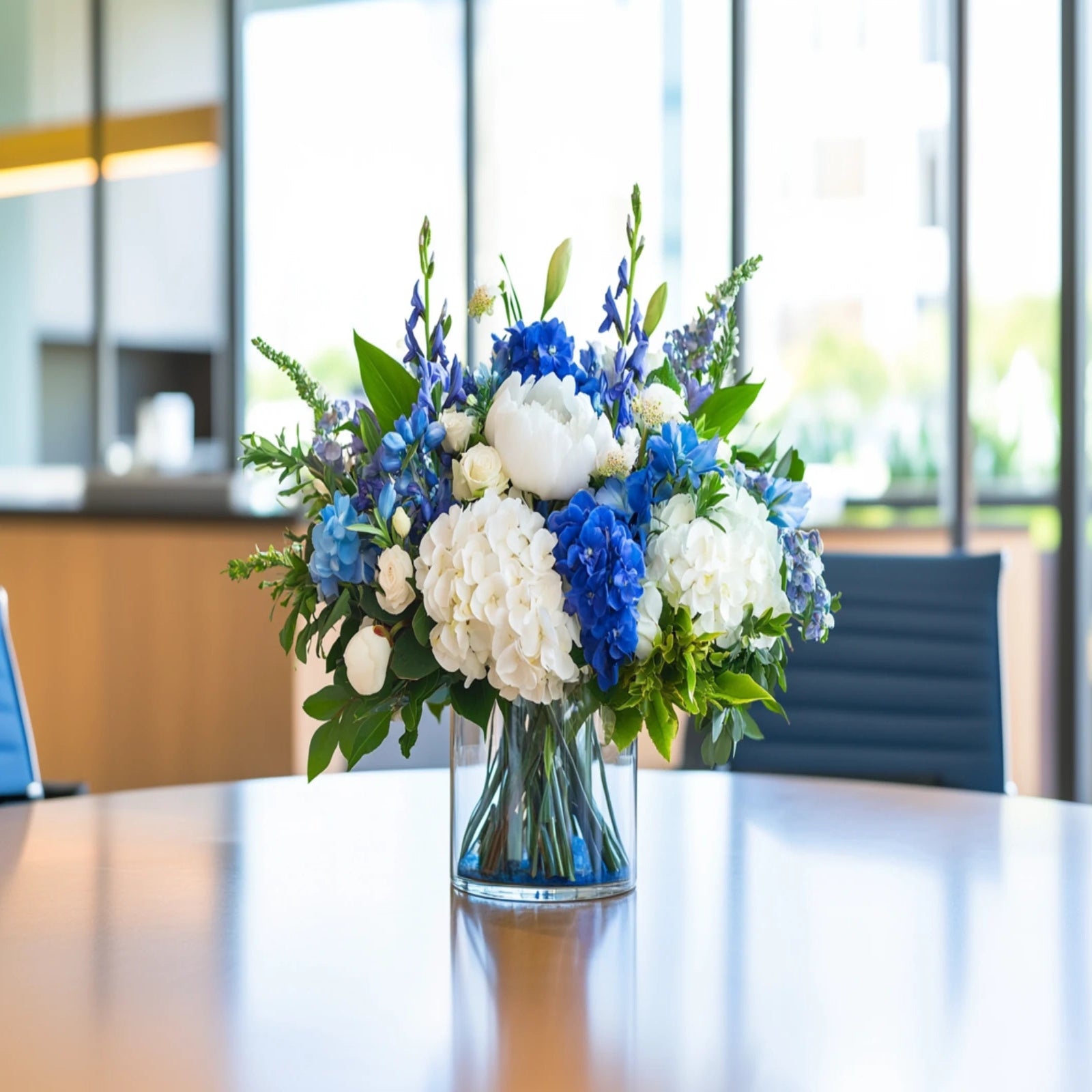 Elegant conference room flower arrangement with blue hydrangeas, white roses, and lush greenery – Flowers Valley
