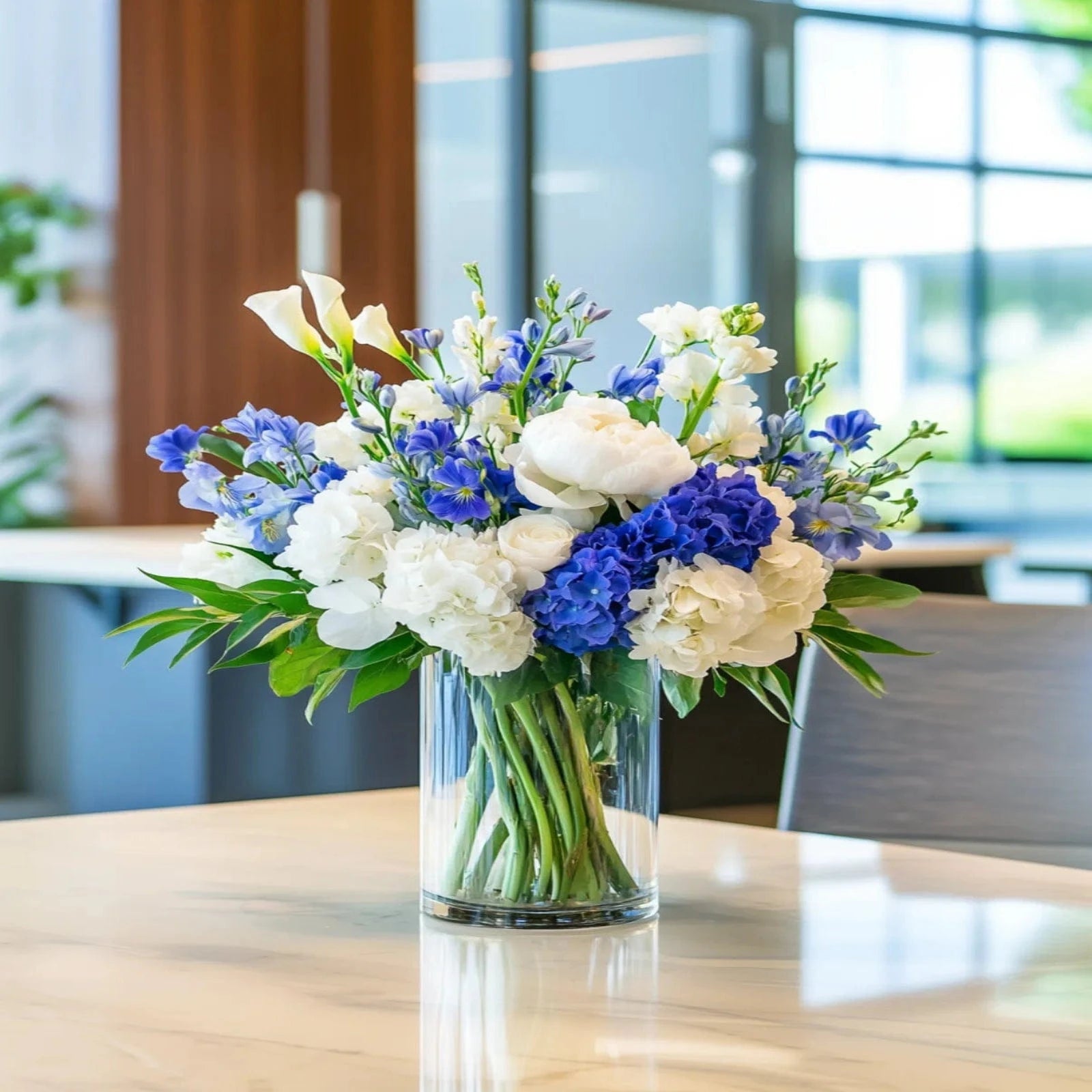 Elegant conference room flower arrangement with blue hydrangeas, white roses, and lush greenery – Flowers Valley
