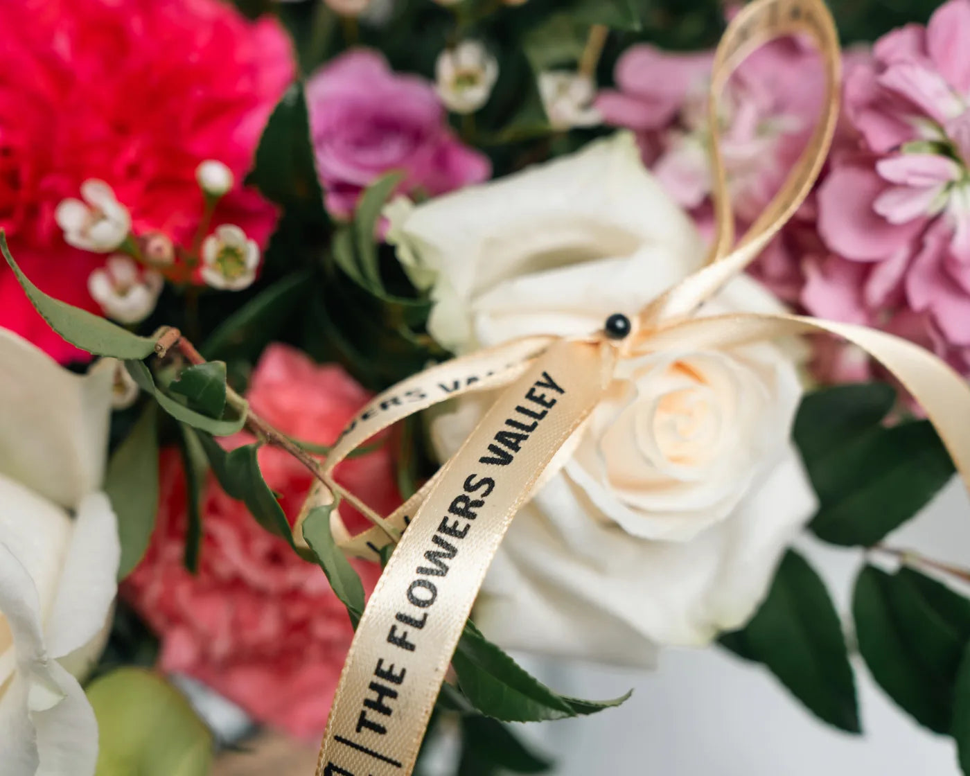 Alt text:
Close-up of white rose with Flowers Valley ribbon in a Corte Madera bouquet – luxury flower delivery