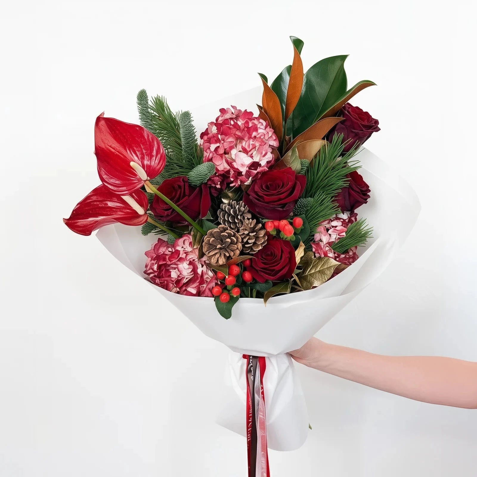 Standard size Crimson Majesty Bouquet with red roses, hydrangeas, protea, and holiday greenery in white wrap