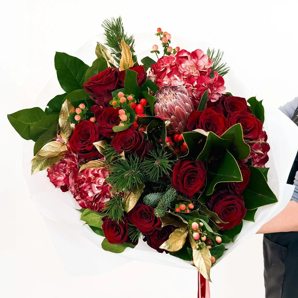 Crimson Majesty Bouquet with red roses, hydrangeas, protea, and holiday greenery