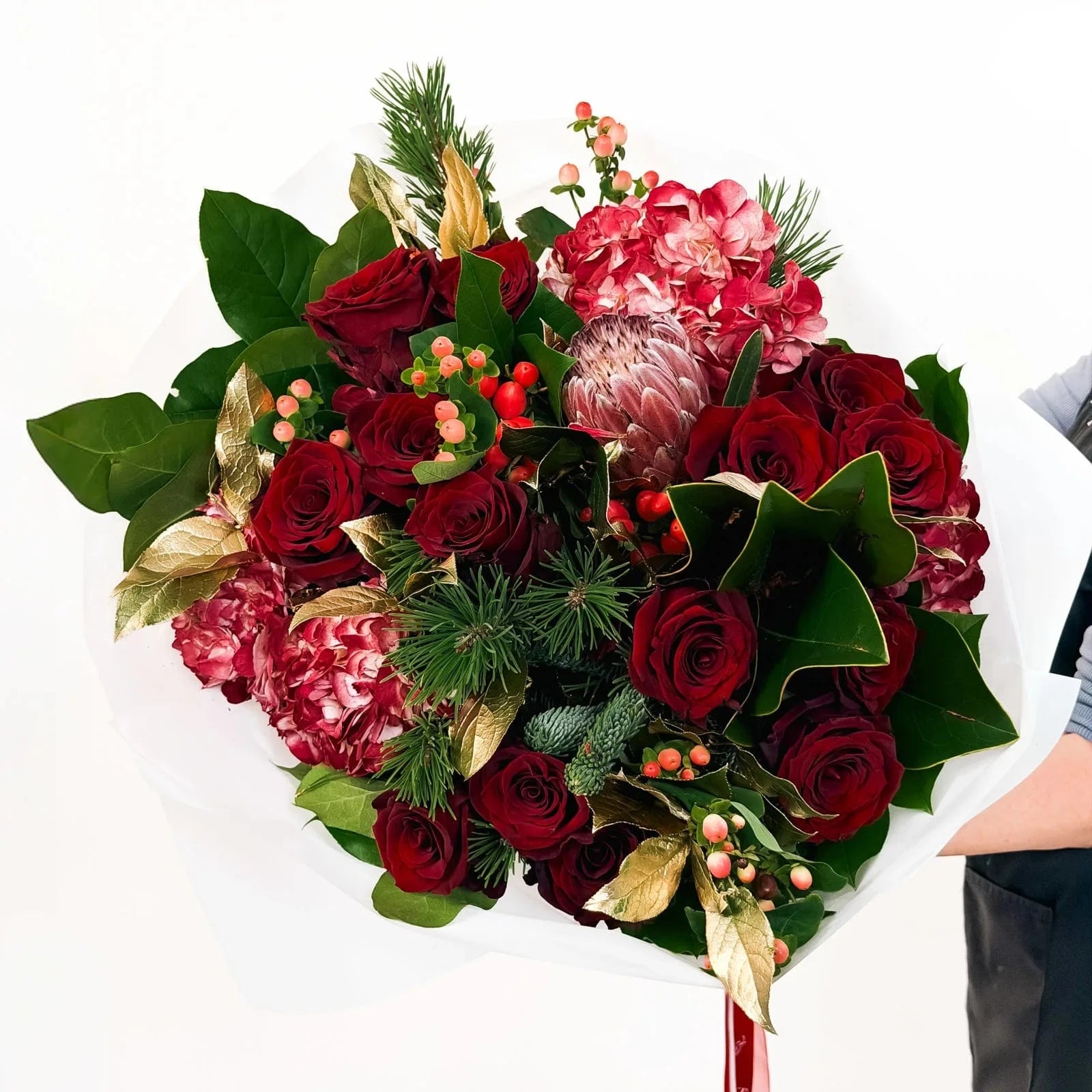 Crimson Majesty Bouquet with red roses, hydrangeas, protea, and holiday greenery