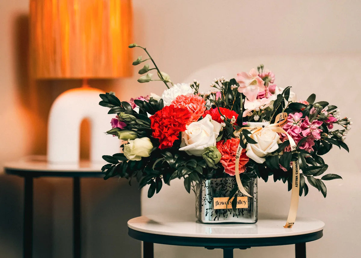Floral arrangement in a glass vase on a table with a blurred background delivered as a flower subscription to the customer