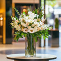 Luxury grand lobby flower display with white roses, lilies, and lush greenery in a tall glass vase – Flowers Valley