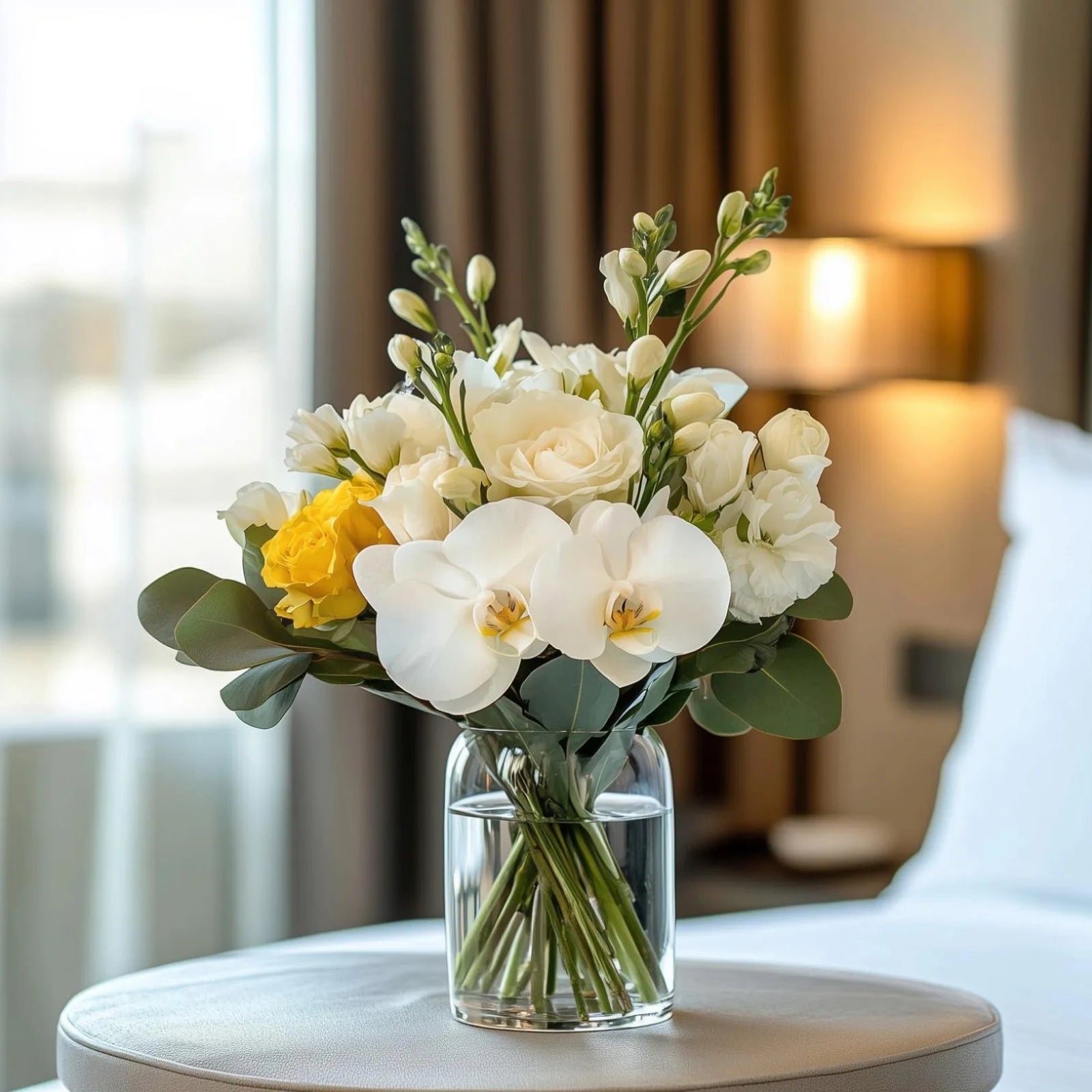 Minimalist guest room flower arrangement with elegant white ranunculus in a clear vase – Flowers Valley