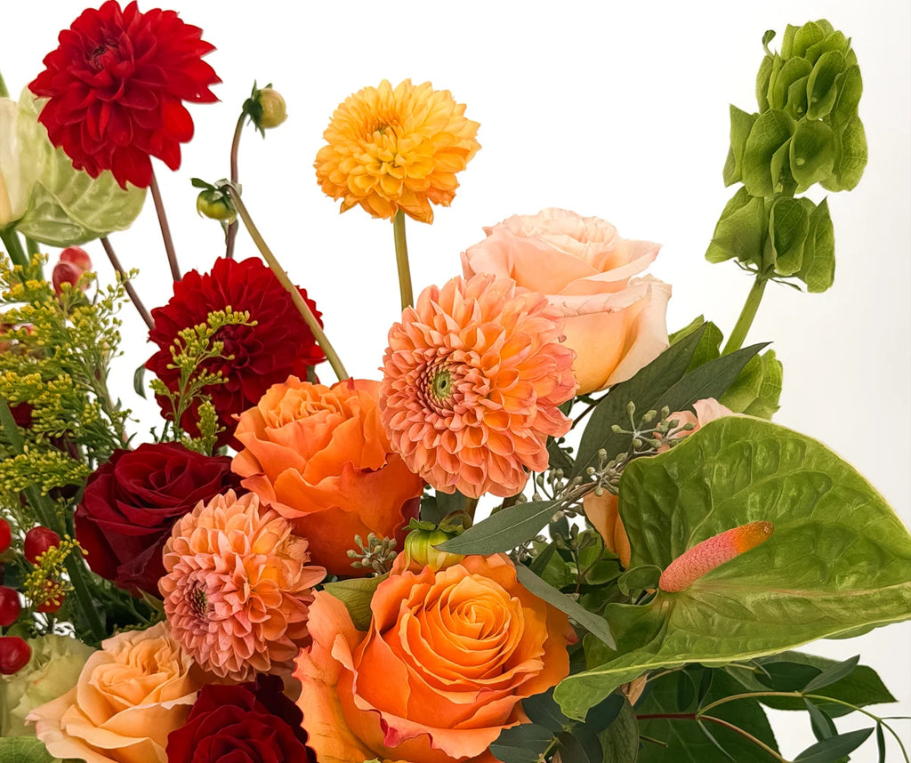 Close-up of peach dahlias, orange garden roses, red roses, and green anthurium in the Flowers Valley Harvest Basket
