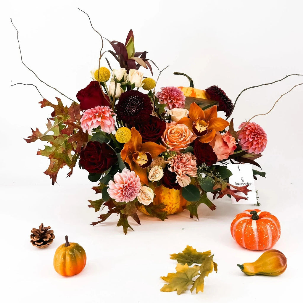 Harvest Majesty Pumpkin Arrangement with dahlias, roses, orchids, and fall foliage in pumpkin base