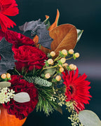 Close-up of Haunted Elegance Pumpkin Arrangement featuring skull, bats, and red gerbera daisy