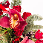 Close-up of cymbidium orchid and red roses in Holiday Orchid Rose Tree arrangement