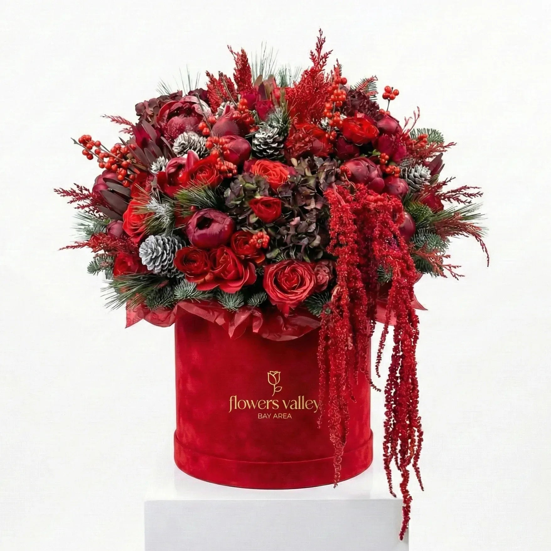 Luxury holiday flower box with deep red blooms and seasonal greenery in a velvet box by Flowers Valley