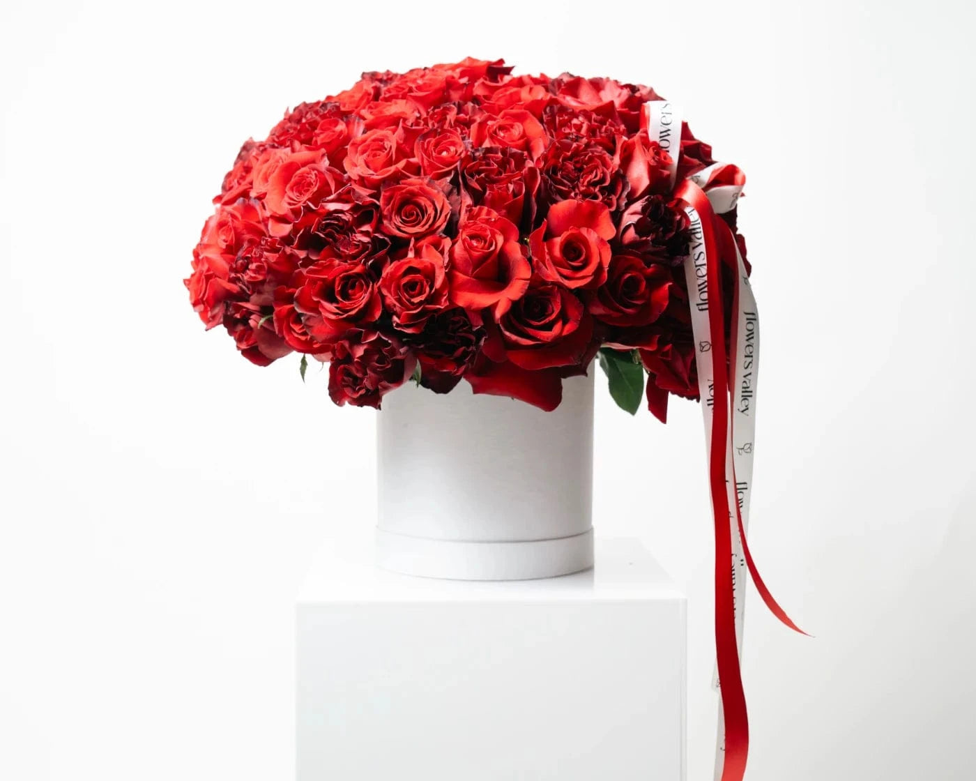 Elegant luxury bouquet of vibrant red roses arranged in a white hatbox with ribbon – Flowers Valley Castro Valley flower delivery