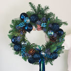 Midnight Blue Wreath with sapphire ornaments and evergreens held for display by Flowers Valley