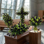 Midnight calla tribute collection for the funeral service featuring Standing spray, cross, casket arrangement and a vase arrangement that includes dark purple calla lilies 