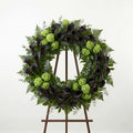 Modern funeral wreath with dark purple calla lilies and green hydrangea