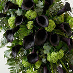 Close-up of calla lilies and greenery in standing funeral spray