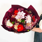 Midnight Ruby bouquet in Grand size with abundant red roses, burgundy dahlias, and seasonal blooms