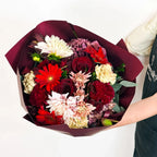 Midnight Ruby bouquet in Standard size with red roses, dahlias, and carnations wrapped in burgundy paper