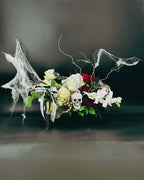 Full view of Midnight Spell Arrangement with eerie cobwebs, roses, orchids, and skull