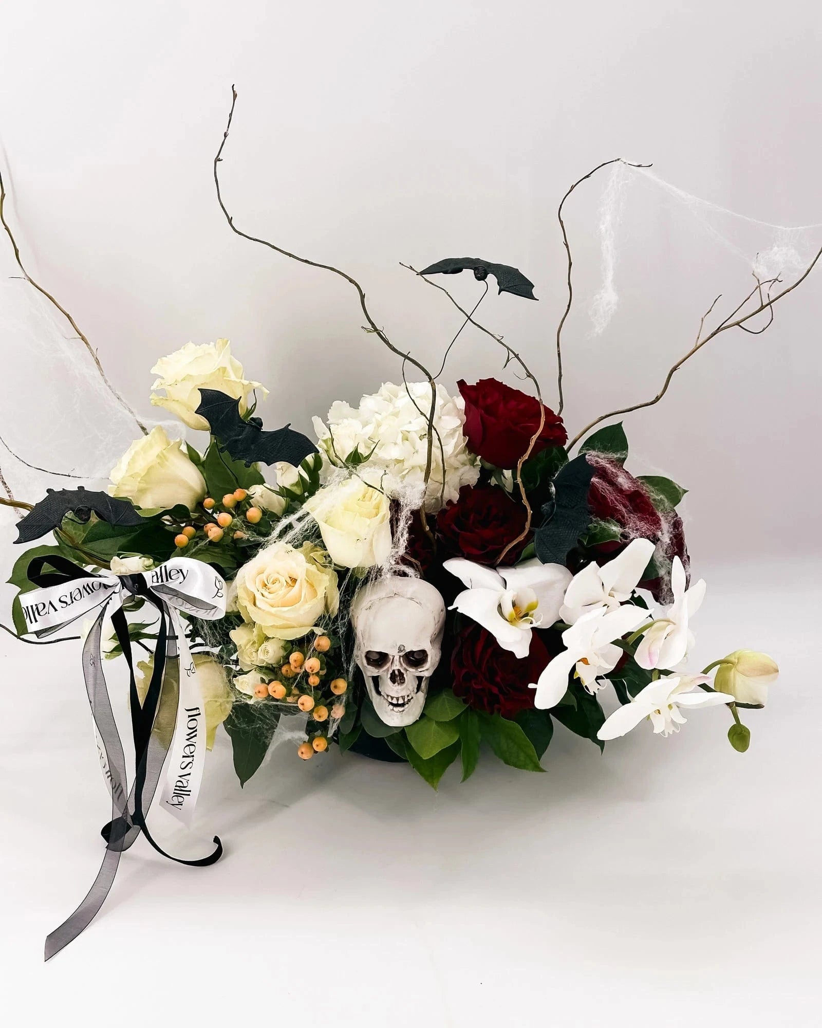 Side angle of Midnight Spell Arrangement with twisted branches, cobwebs, and Halloween accents
