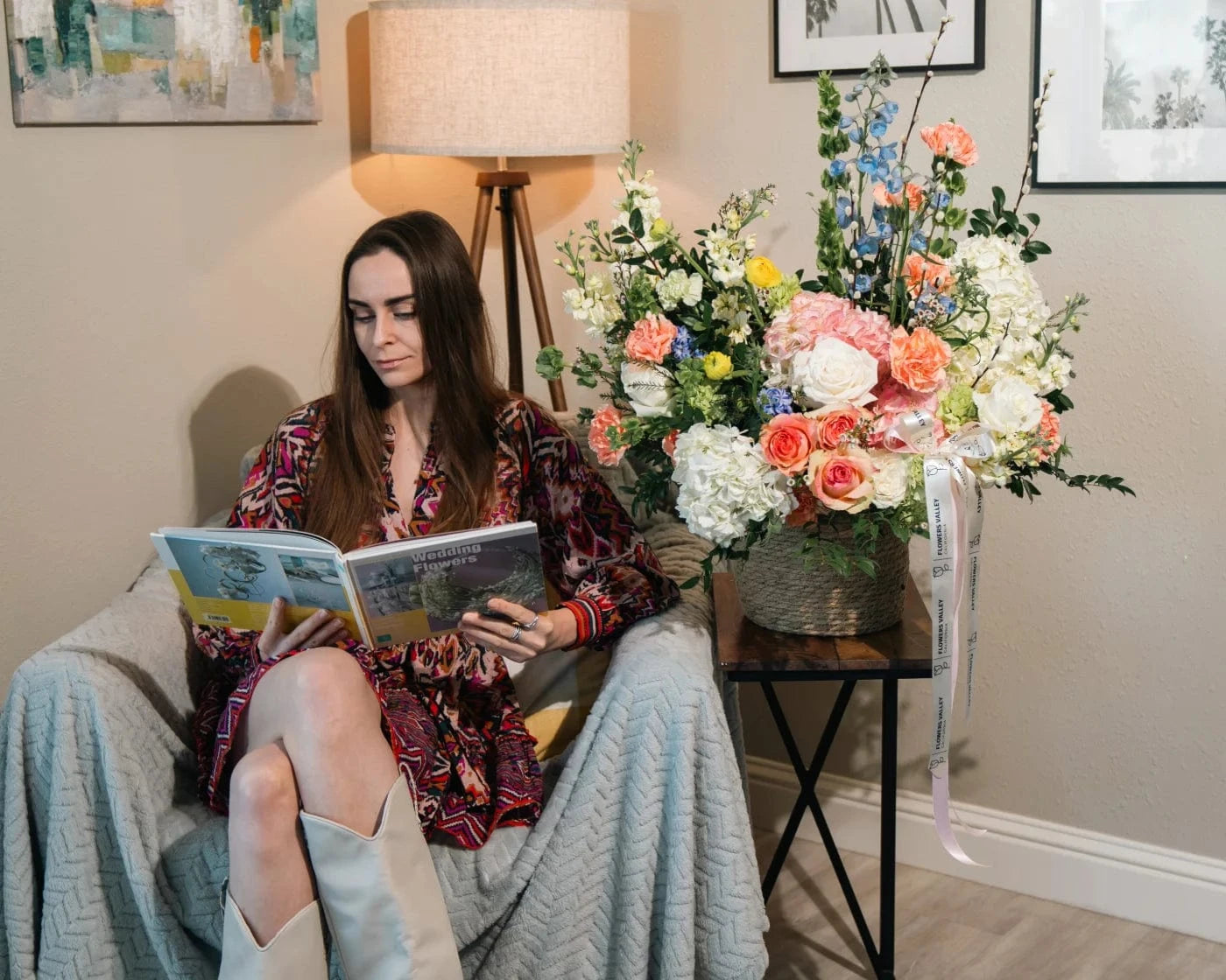 Woman reading in a cozy Moraga home with elegant flower arrangement on side table – Flowers Valley delivery