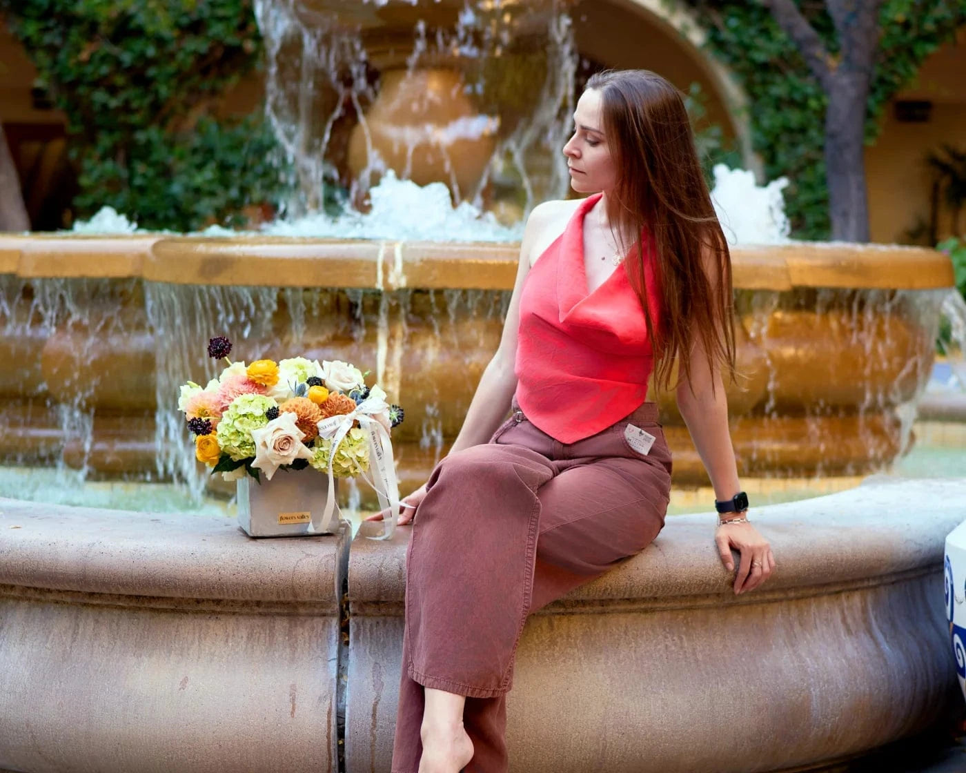 Woman sitting by fountain with fresh bouquet – Flowers Valley same-day flower delivery in Pittsburg, CA