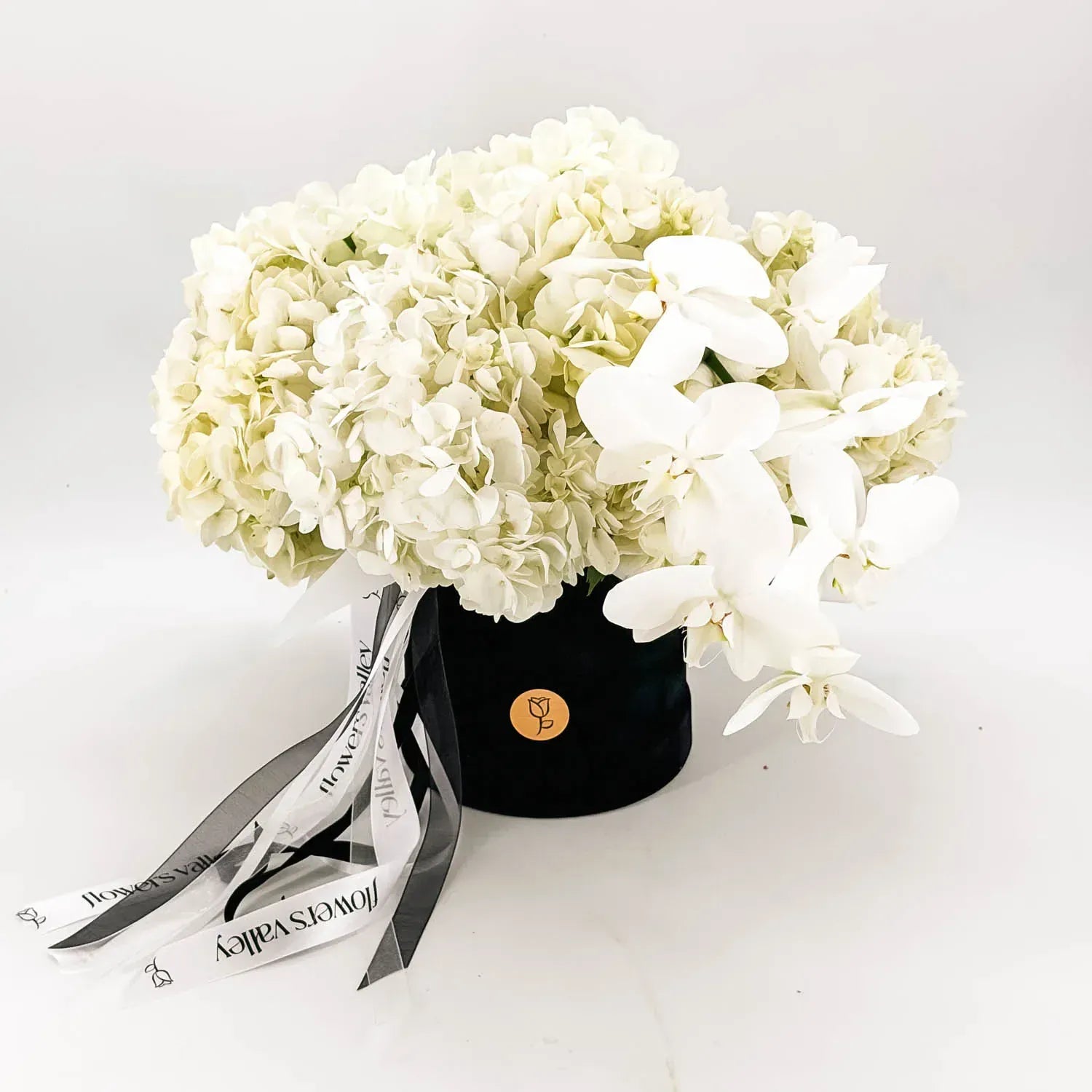 Elegant white orchid and hydrangea sympathy flowers designed by Flowers Valley
