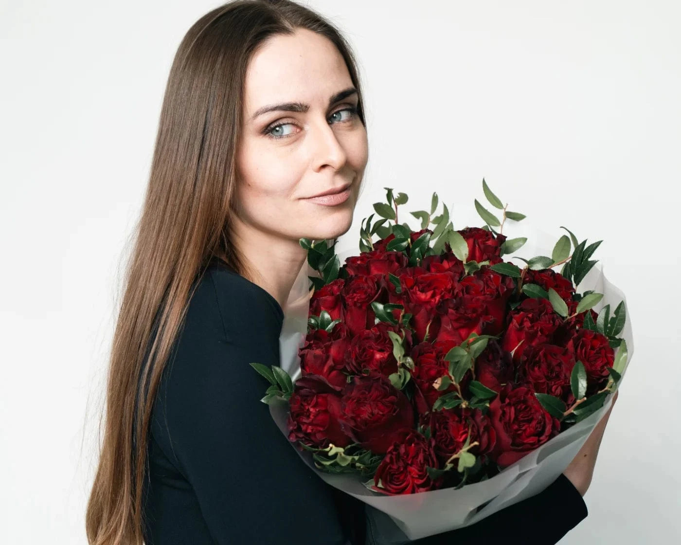 Woman holding a large bouquet of lush red roses with greenery – Flowers Valley flower delivery in Pacifica, CA