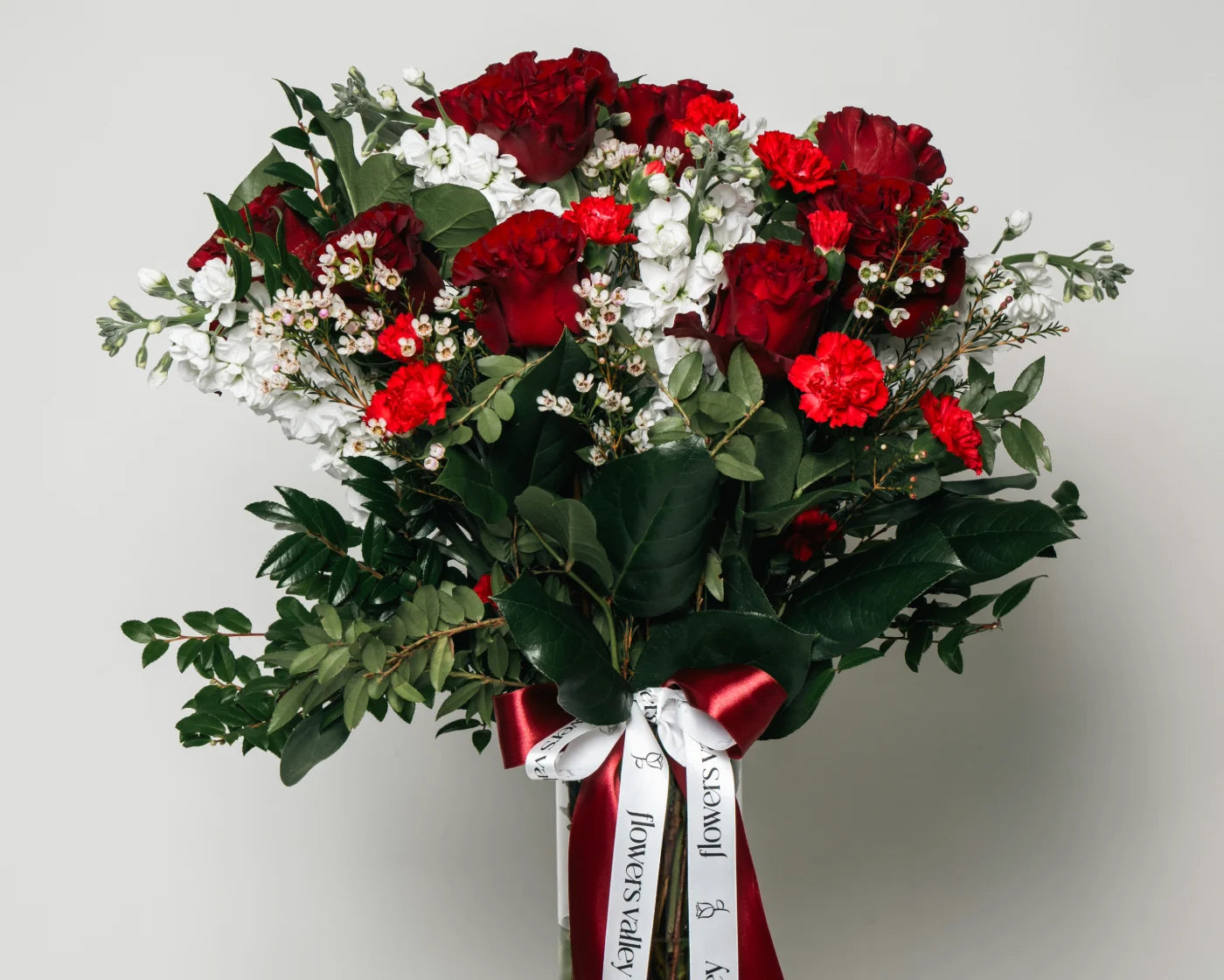 Elegant bouquet of red roses and carnations with white accent flowers and greenery, tied with red ribbon – Flowers Valley Millbrae flower delivery