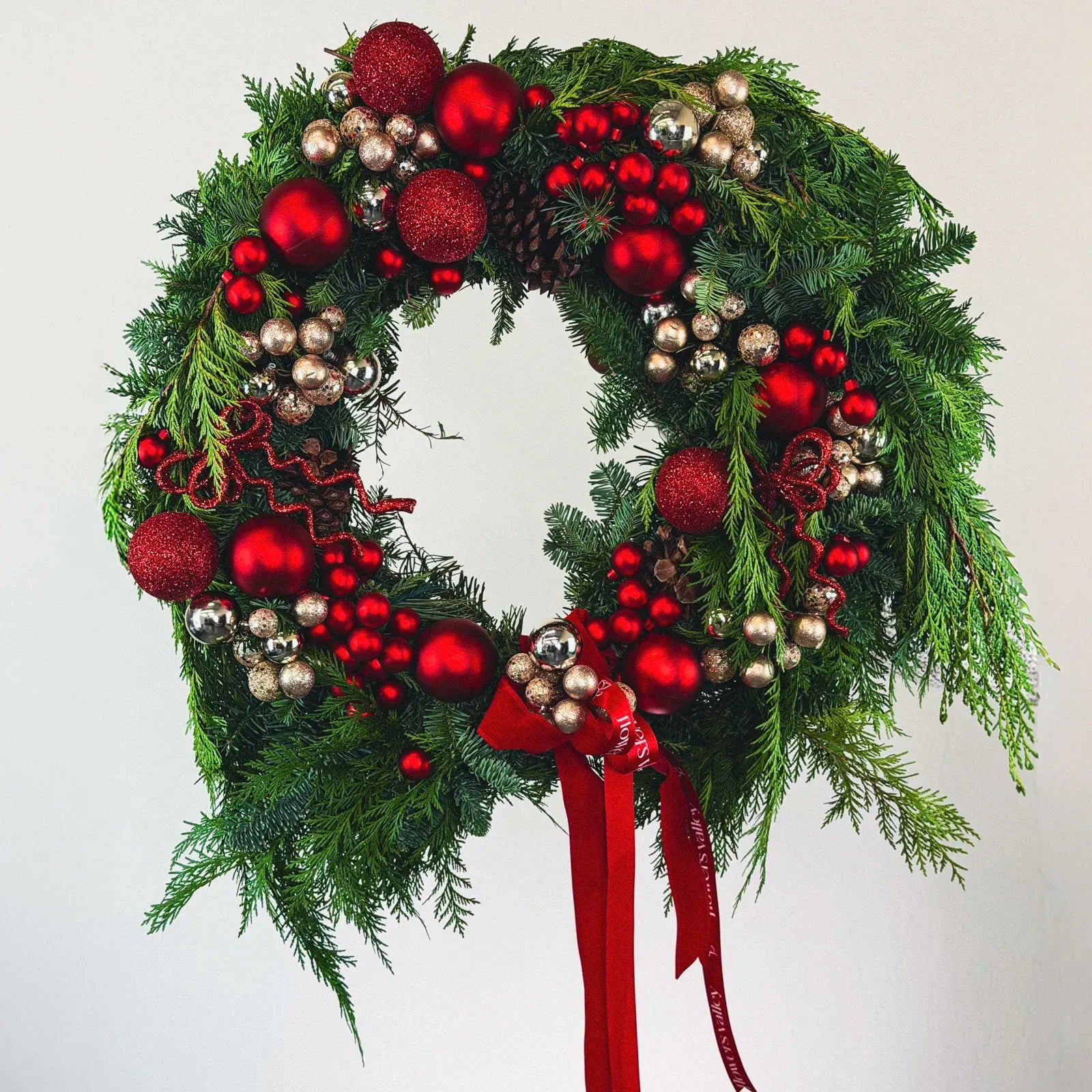 Red Velvet Holiday Wreath with red ornaments and evergreens by Flowers Valley