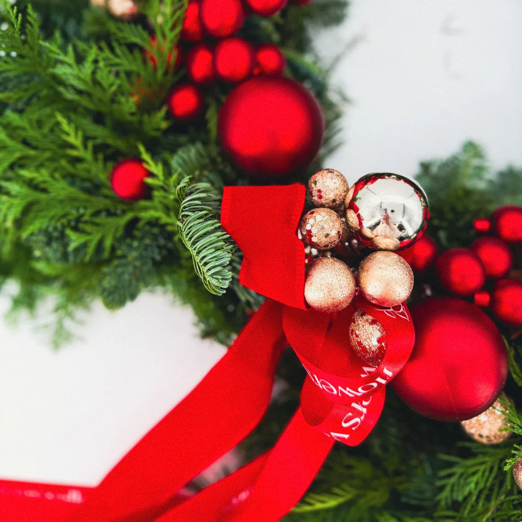 Close-up of luxury red holiday wreath with gold accents and ribbons