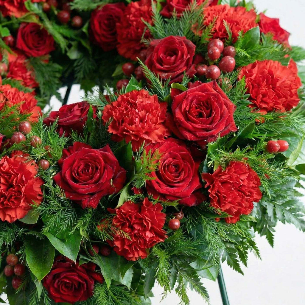 Close-up photo of the Redline Tribute Funeral Wreath featuring red roses and carnations
