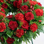 Close-up photo of the Redline Tribute Funeral Wreath featuring red roses and carnations
